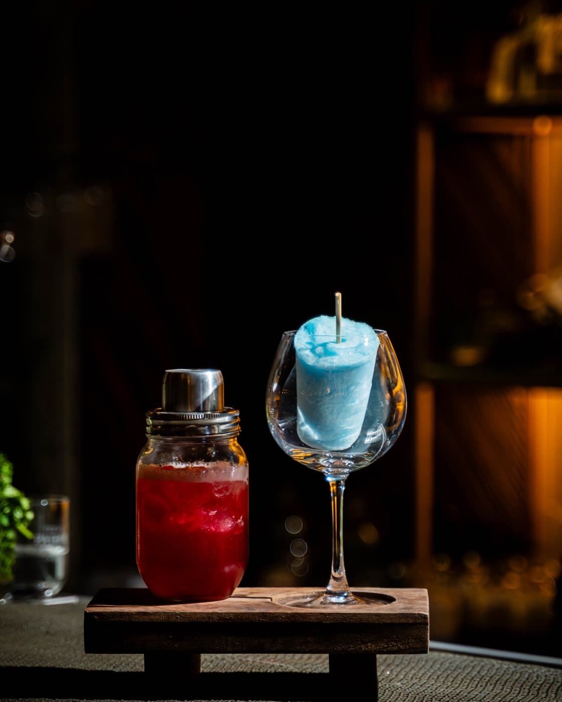 Frozen blue cocktail beside a ruby decanter