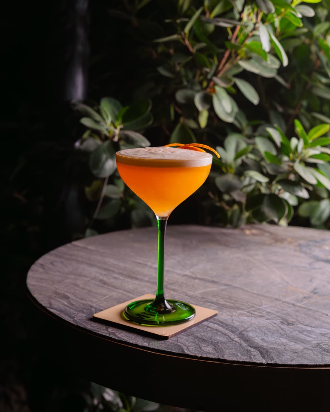 Amber coupe with an orange twist on a green stem