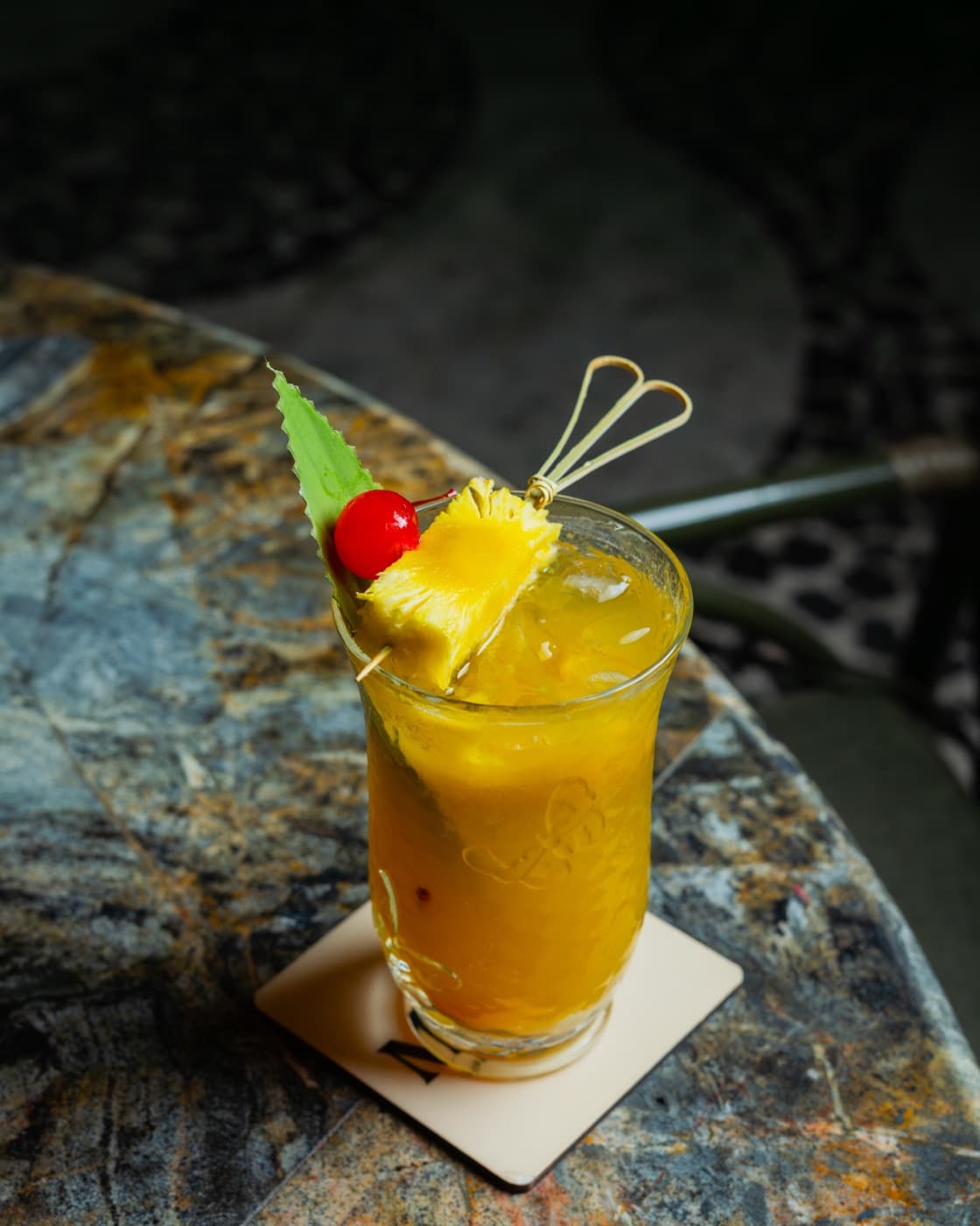 Pineapple-crowned tiki serve on hand-painted stone