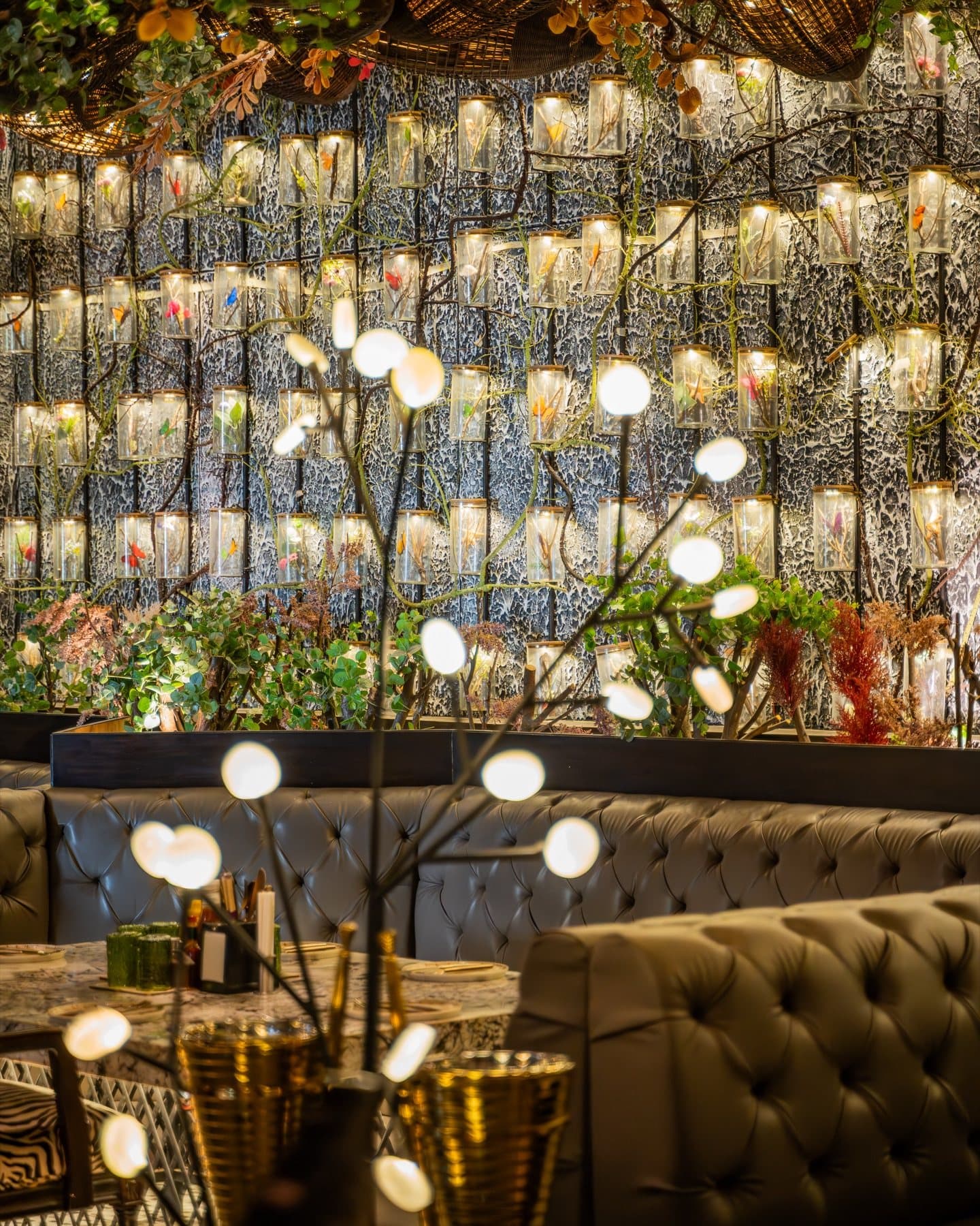 Sculptural lamps glowing against the bottle wall