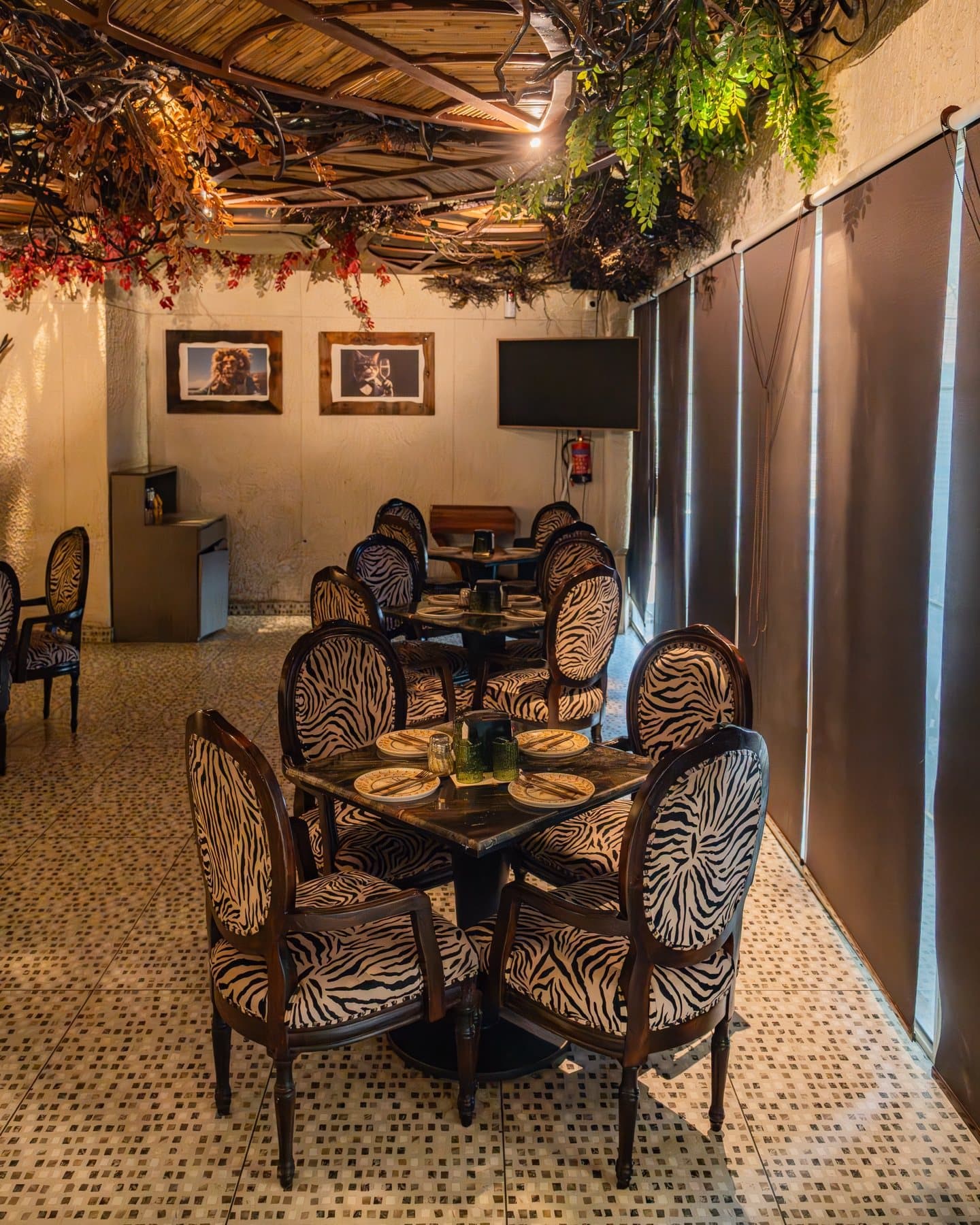 MEZO dining room — mosaic stone floor, zebra chairs and a ceiling of dried botanicals