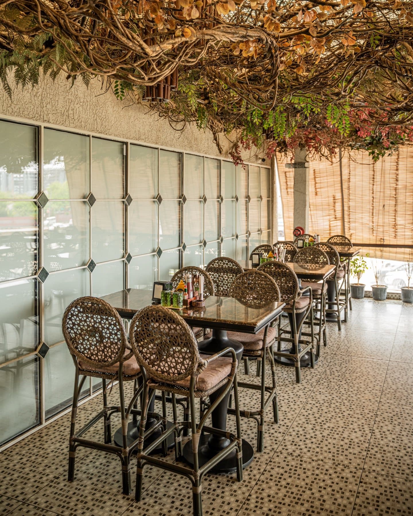 Open-air terrace with cane chairs and pebble mosaic floor