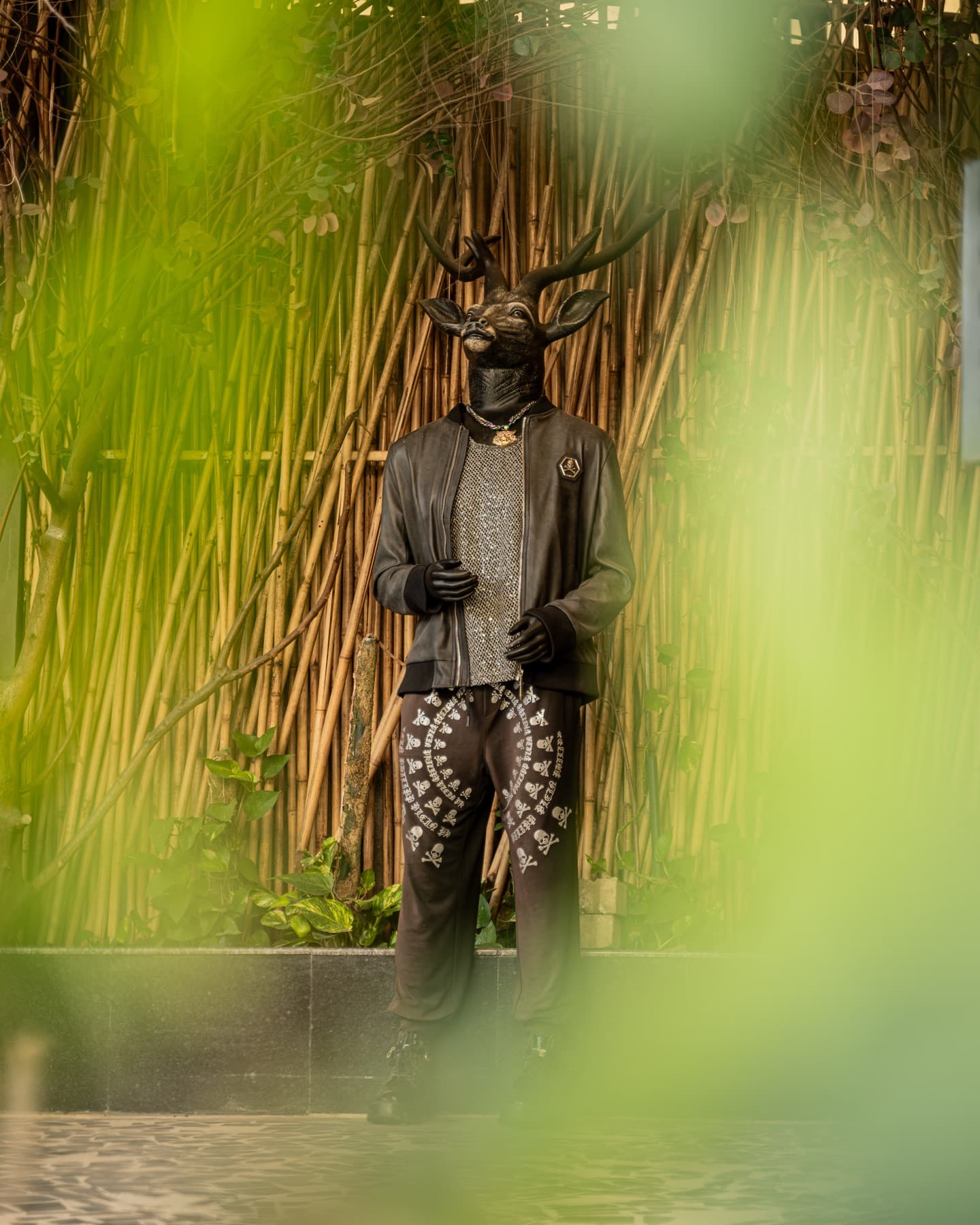 Carved guardian figure standing within the bamboo grove