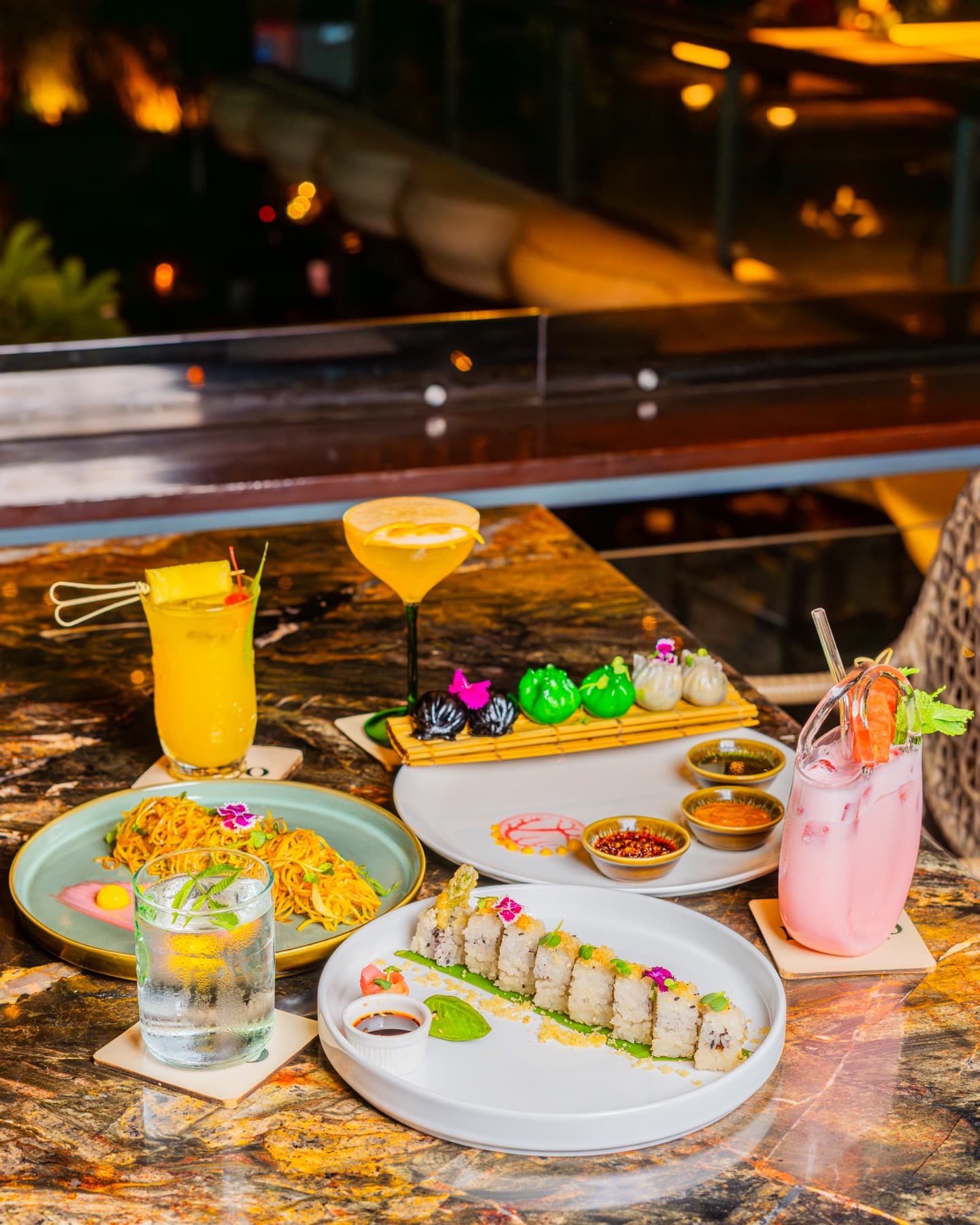 Sushi, noodles and pastel coolers on marbled stone